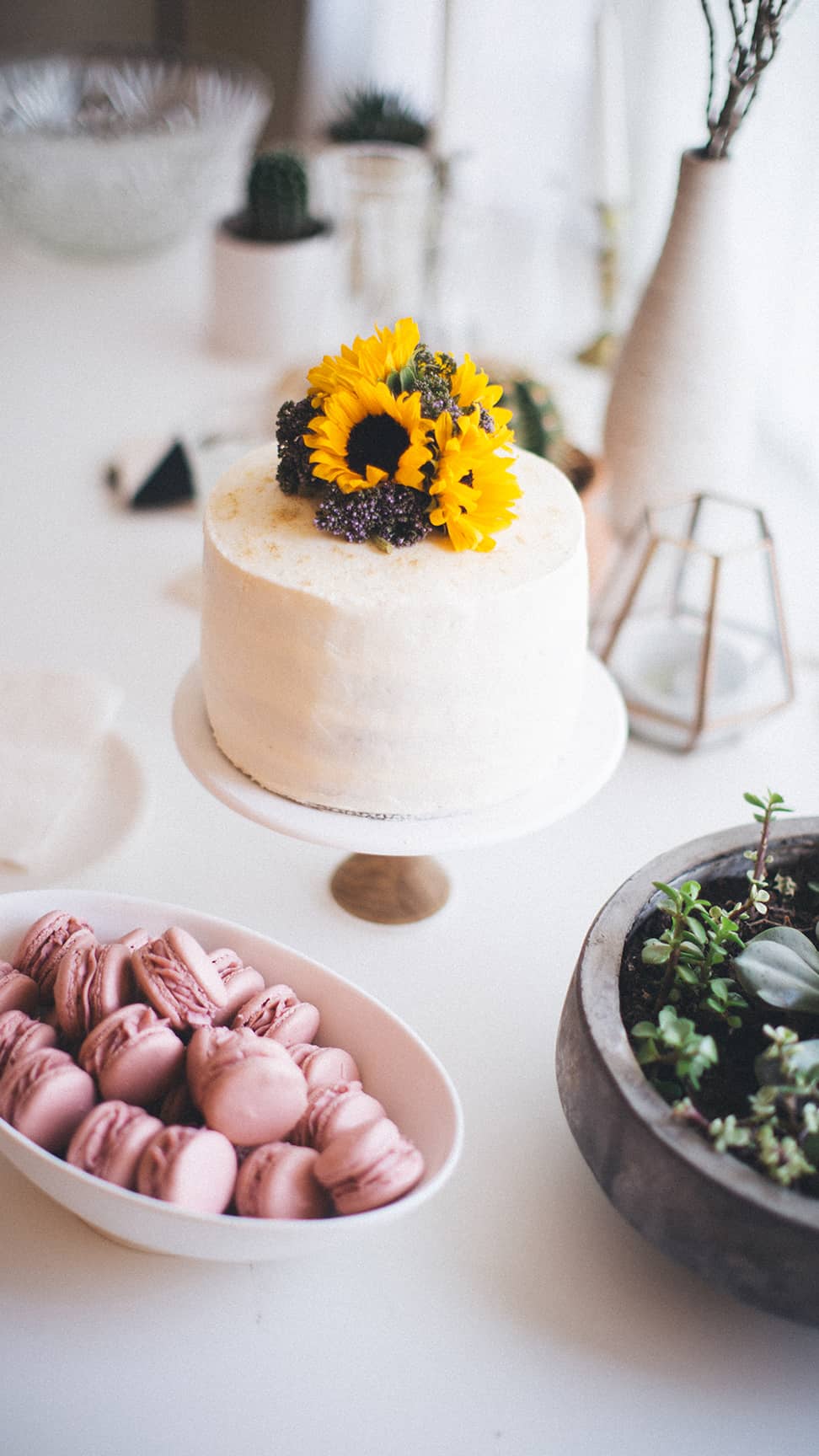Sunflowers on top of a decorated and frosted cake.