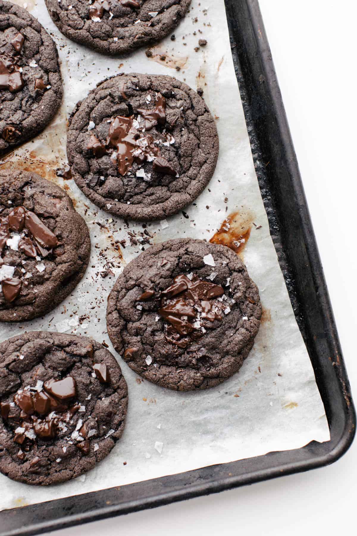 Baked double dark chocolate cookies on a baking sheet with parchment paper.