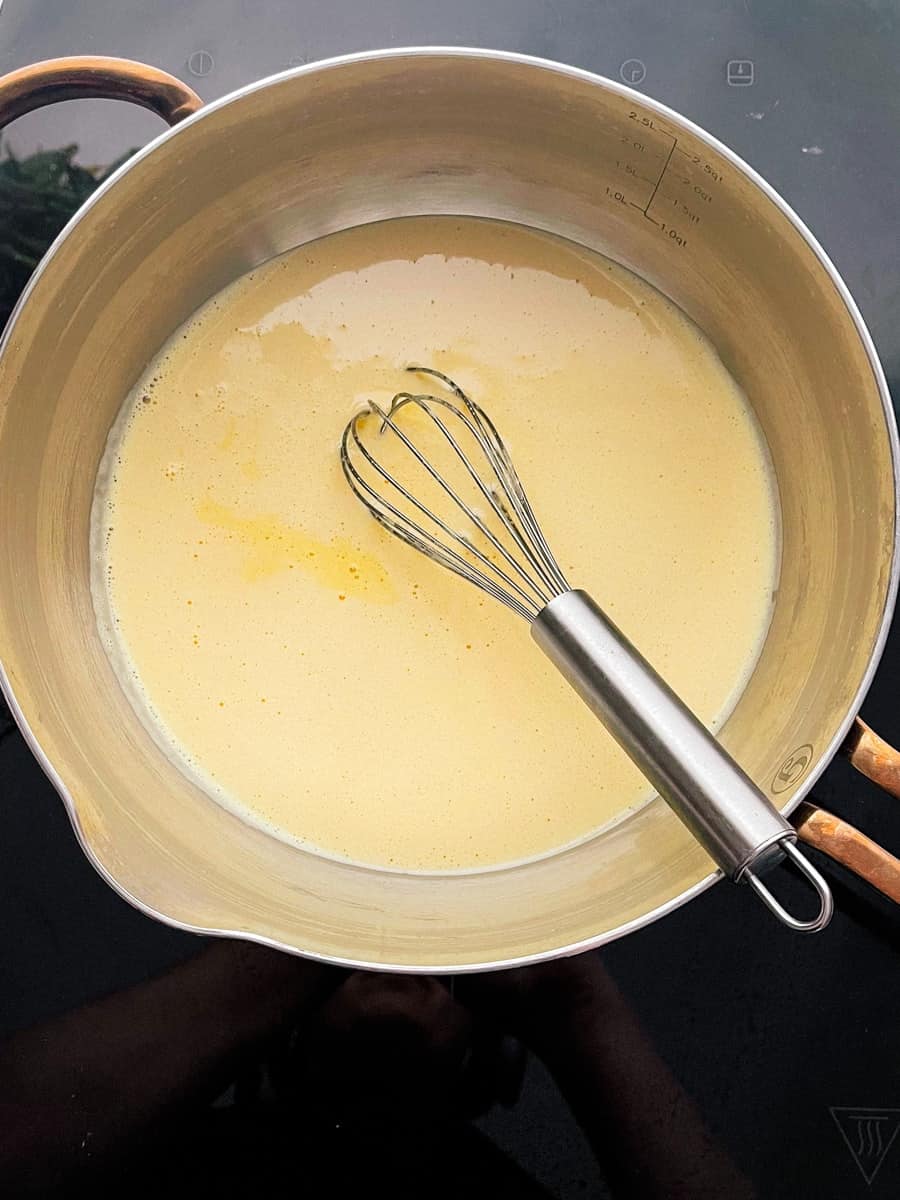 Passion fruit curd in a saucepan on the stove.