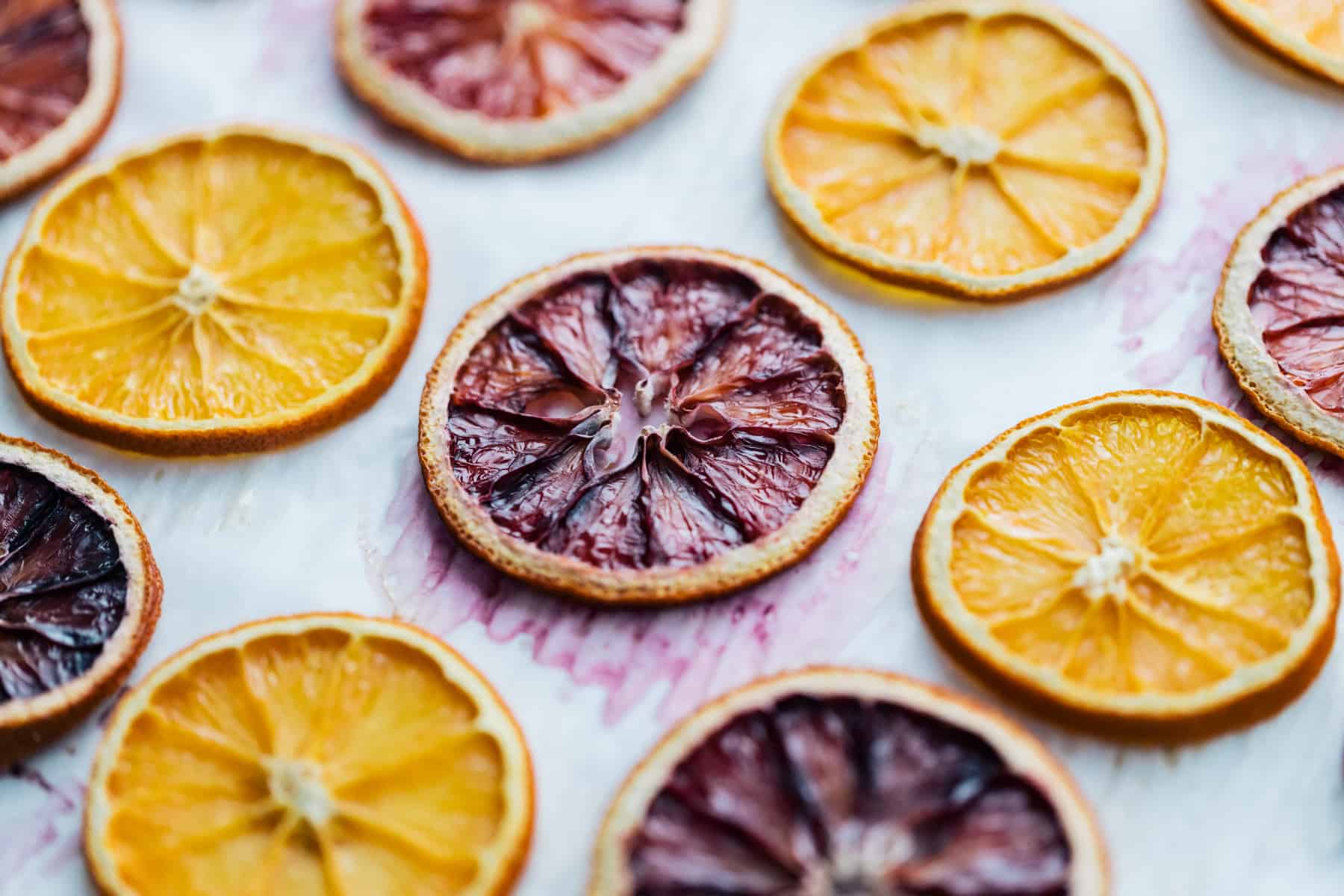 Oven dried oranges on parchment paper.
