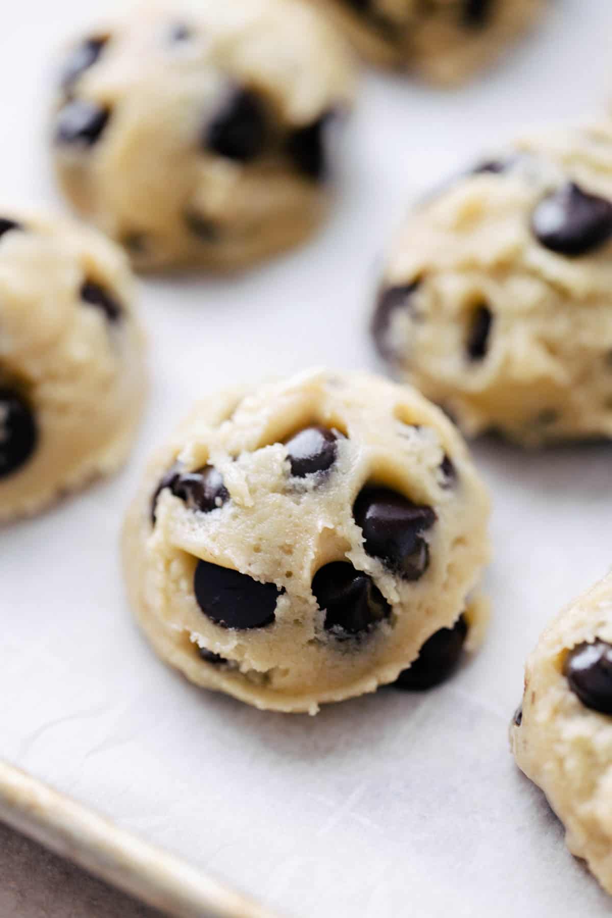 Scooped cookie dough on a cookie sheet. 
