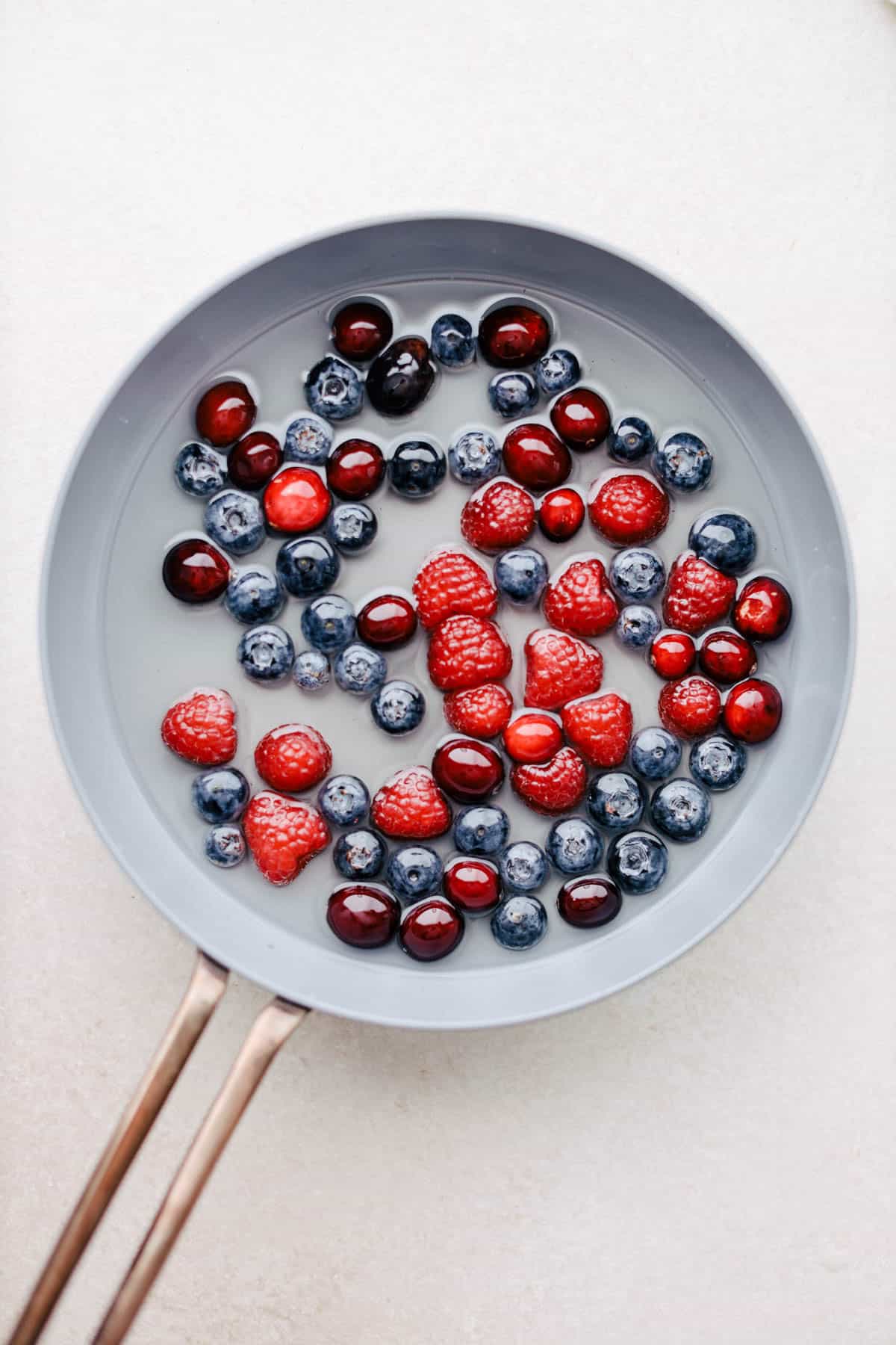 Berries in simple syrup in a saucepan.