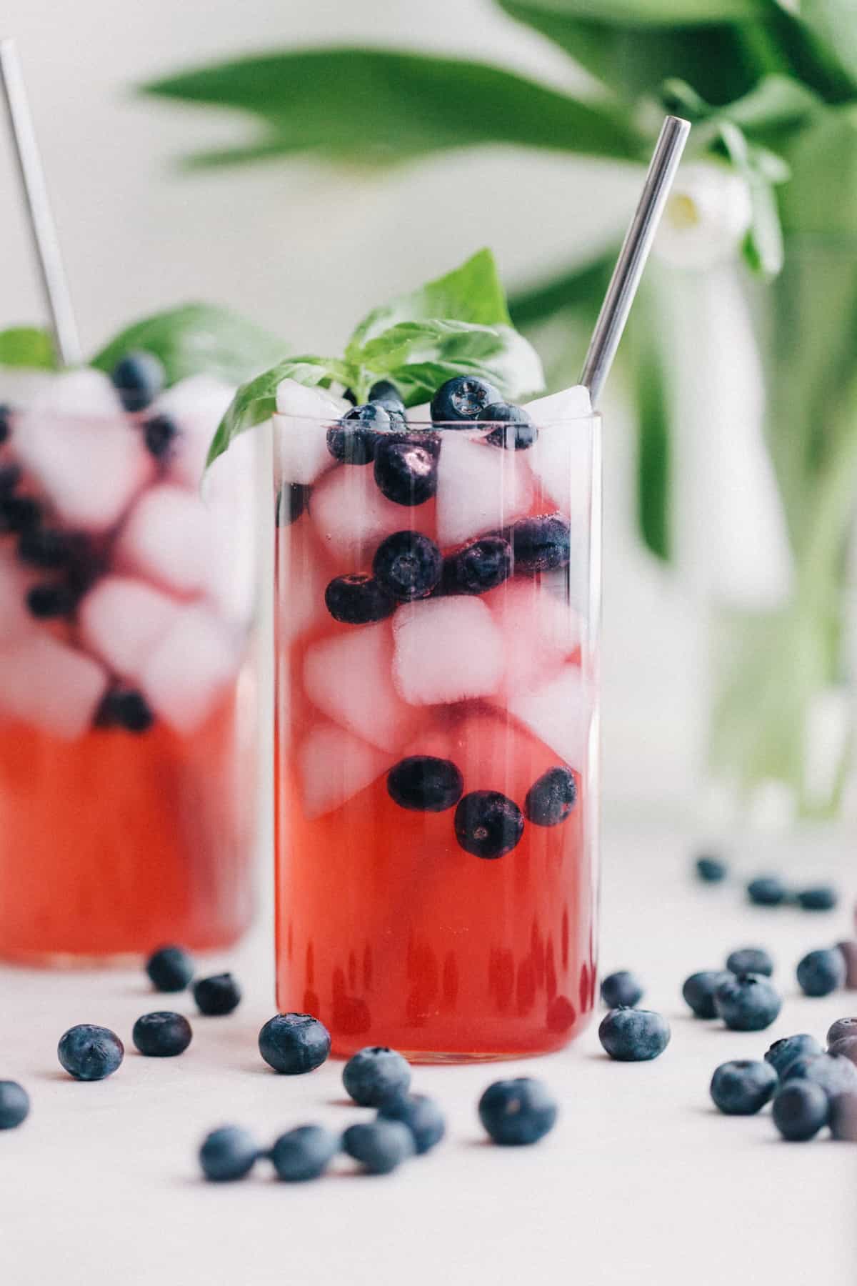 Blueberry shrub with soda water and straw in a glass.