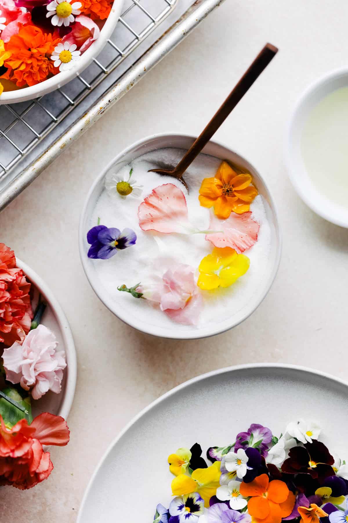 Edible flower petals in a bowl of sugar.