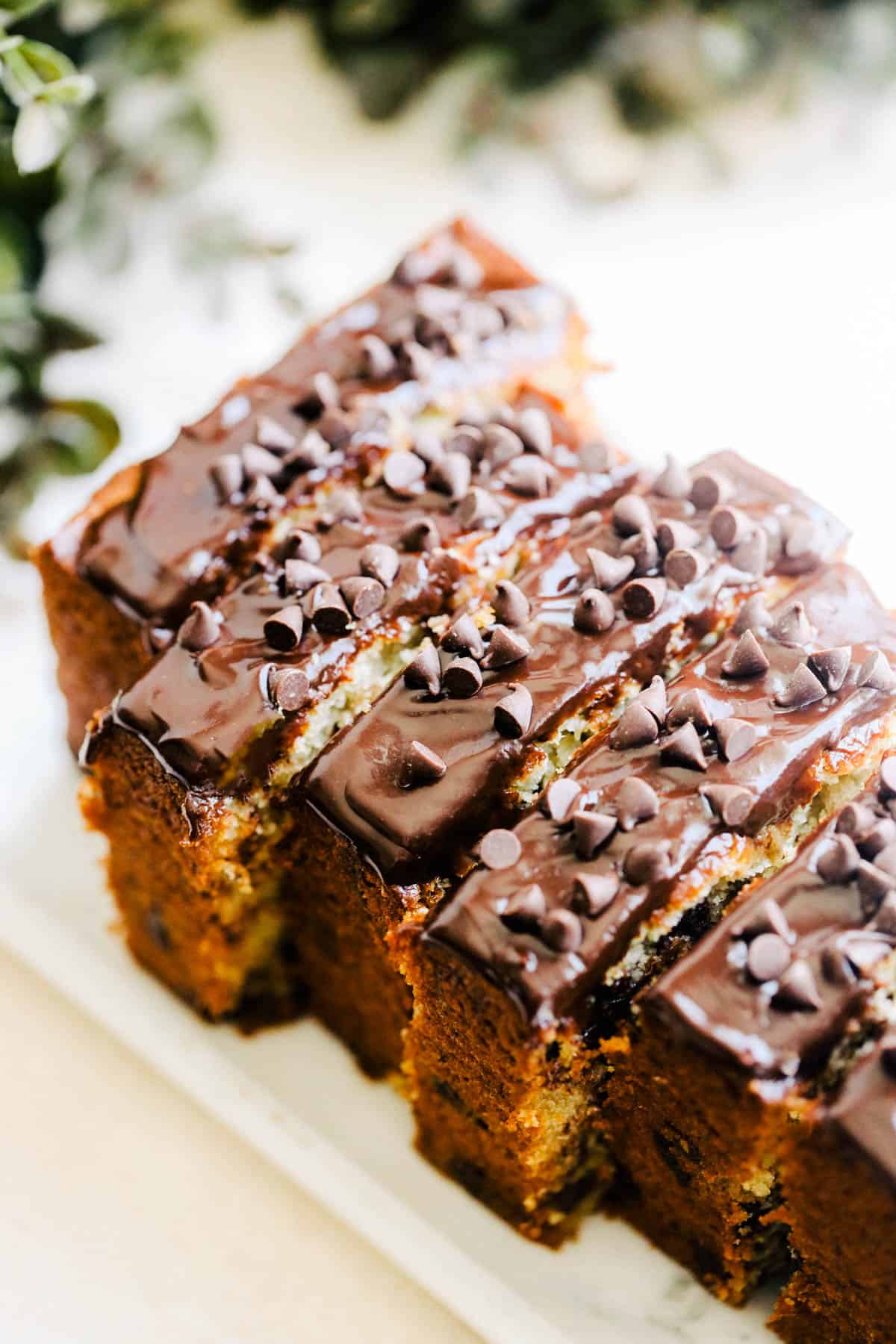 Slices of banana bread covered in chocolate ganache and chocolate chips.