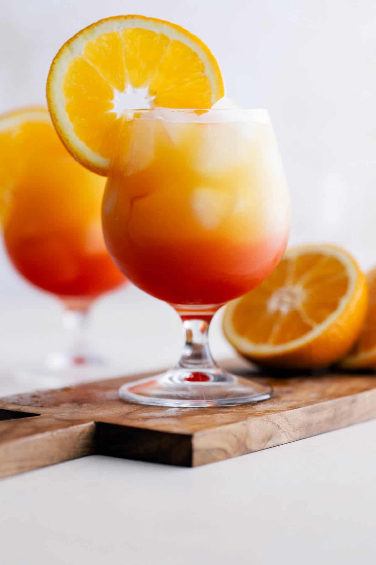 Completed vodka sunrise cocktail garnished with orange slice.