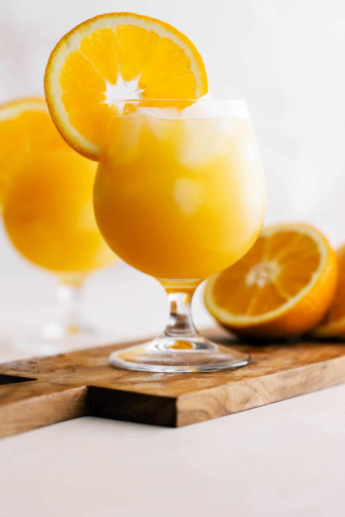 Cocktail glass garnished with an orange wheel.