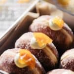 Overhead view of lemon donuts garnished with a candied lemon.