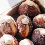 Bavarian cream donuts in a container.