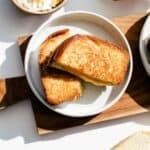 Brioche grilled cheese sandwich cut on a plate.