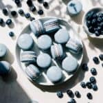 Blueberry macarons on a plate on the counter.