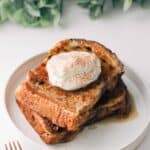 Chocolate chip brioche french toast on a plate with a spoonful of whipped cream on top.
