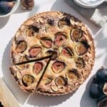 Top down photo of a fig tart with frangipane and a slice taken out.