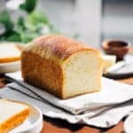 Sourdough brioche loaf on the counter with a dew slices on a plate.