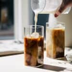 Pouring almond milk into espresso.