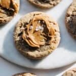Cookie butter cookies on a plate with cookie butter and flaky salt on top.