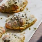 Pistachio croissants on a serving board in the sun.
