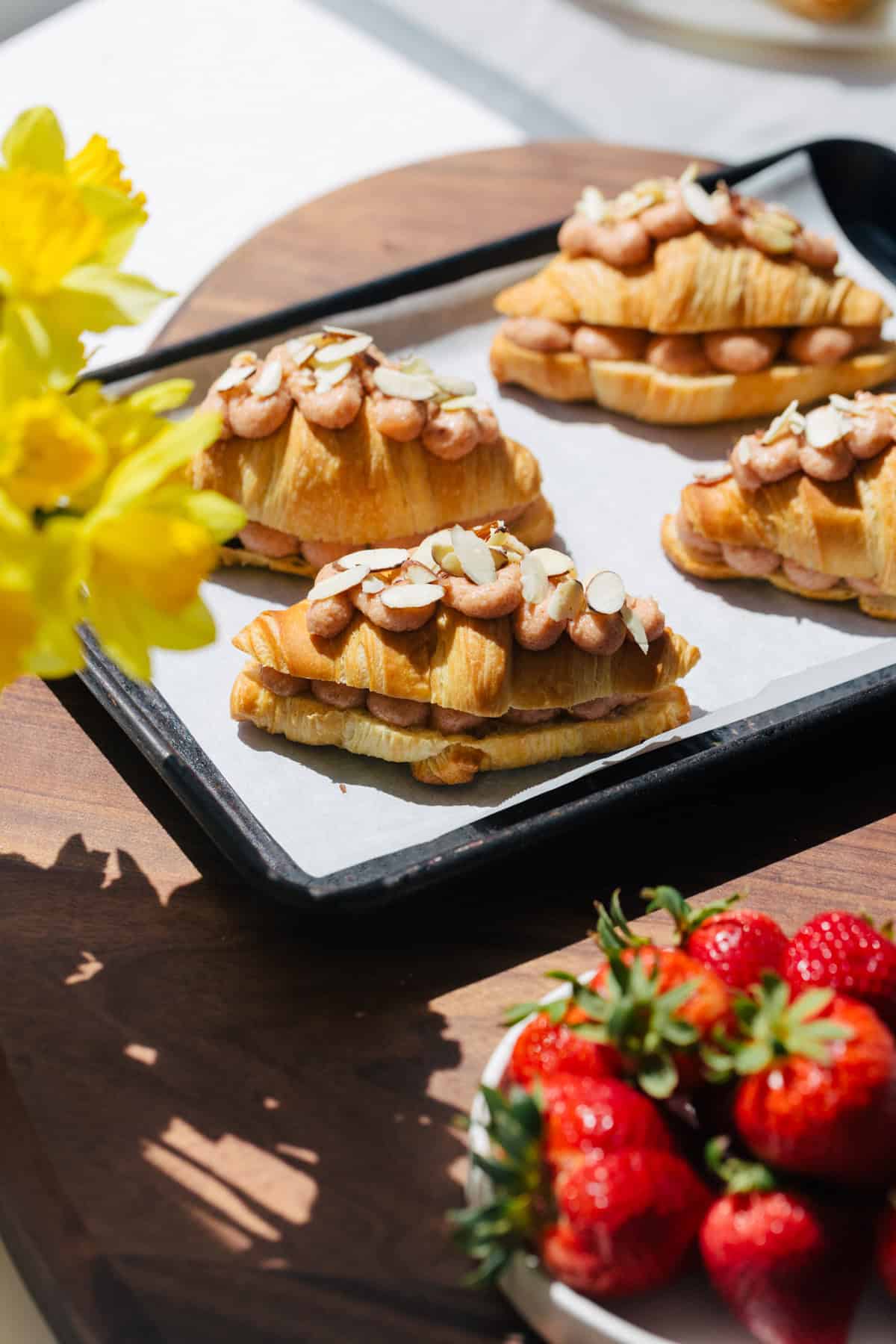 Strawberry croissants ready to bake garnished with sliced almonds. 