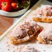 Strawberry croissants on a serving board in the sun.