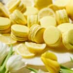 Lemon macarons on the counter filled with lemon buttercream and curd.