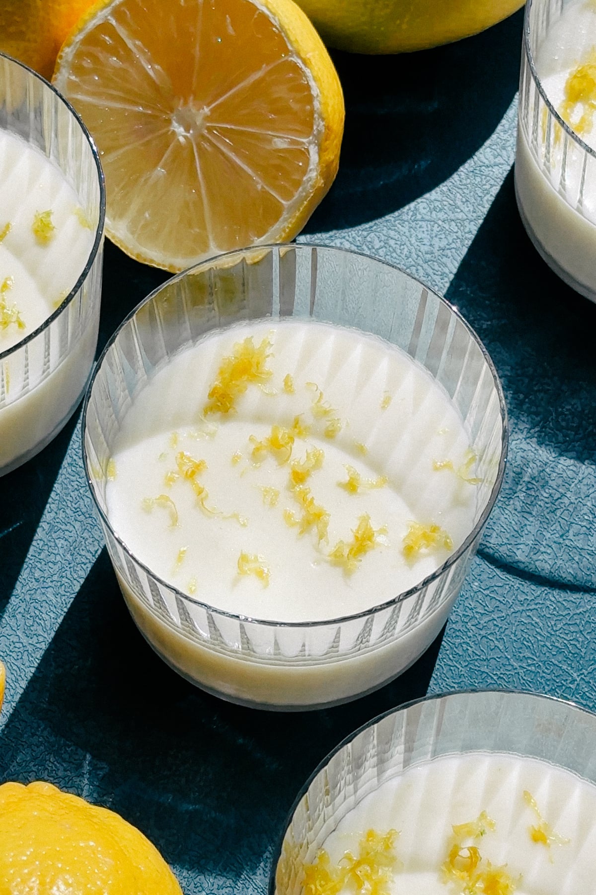 Lemon posset with lemon zest on top on a serving board. 