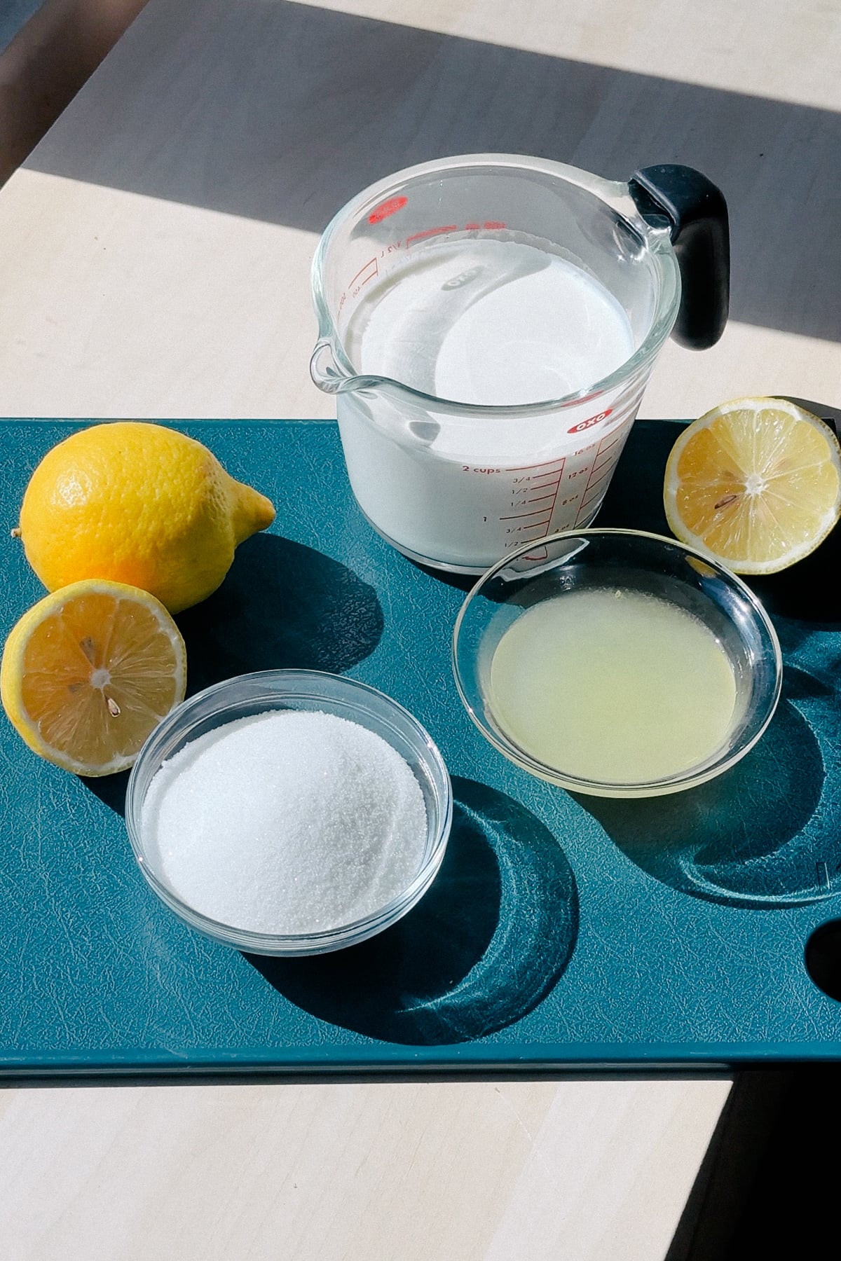 Ingredients needed to make a lemon posset on a cutting board.