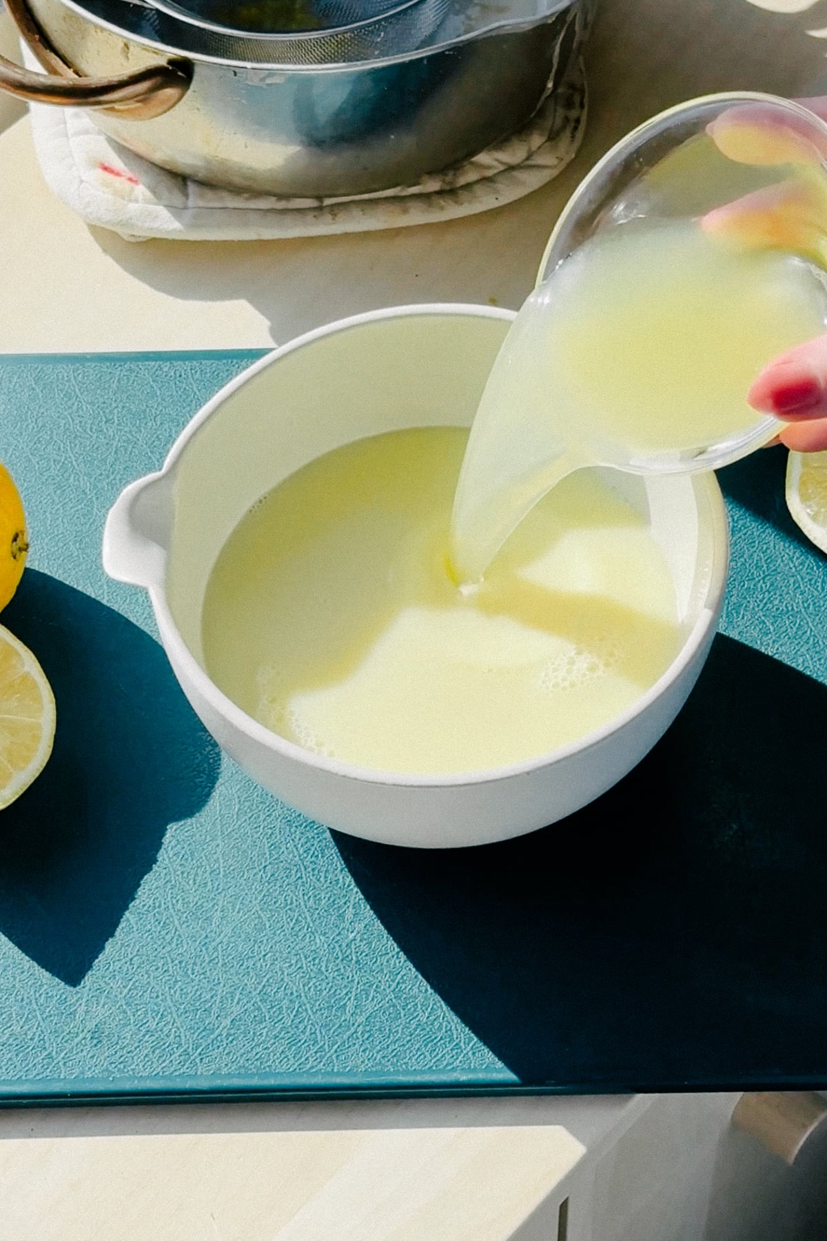 Adding lemon juice into the posset base.