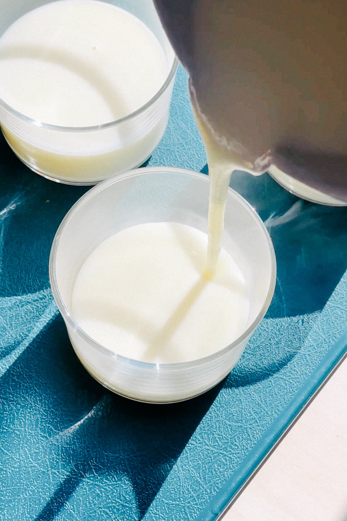 Pouring lime posset into a cup to set.