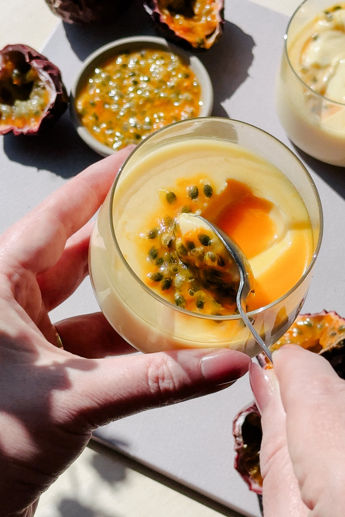 Scooping a spoonful of set passion fruit puree with a spoon 