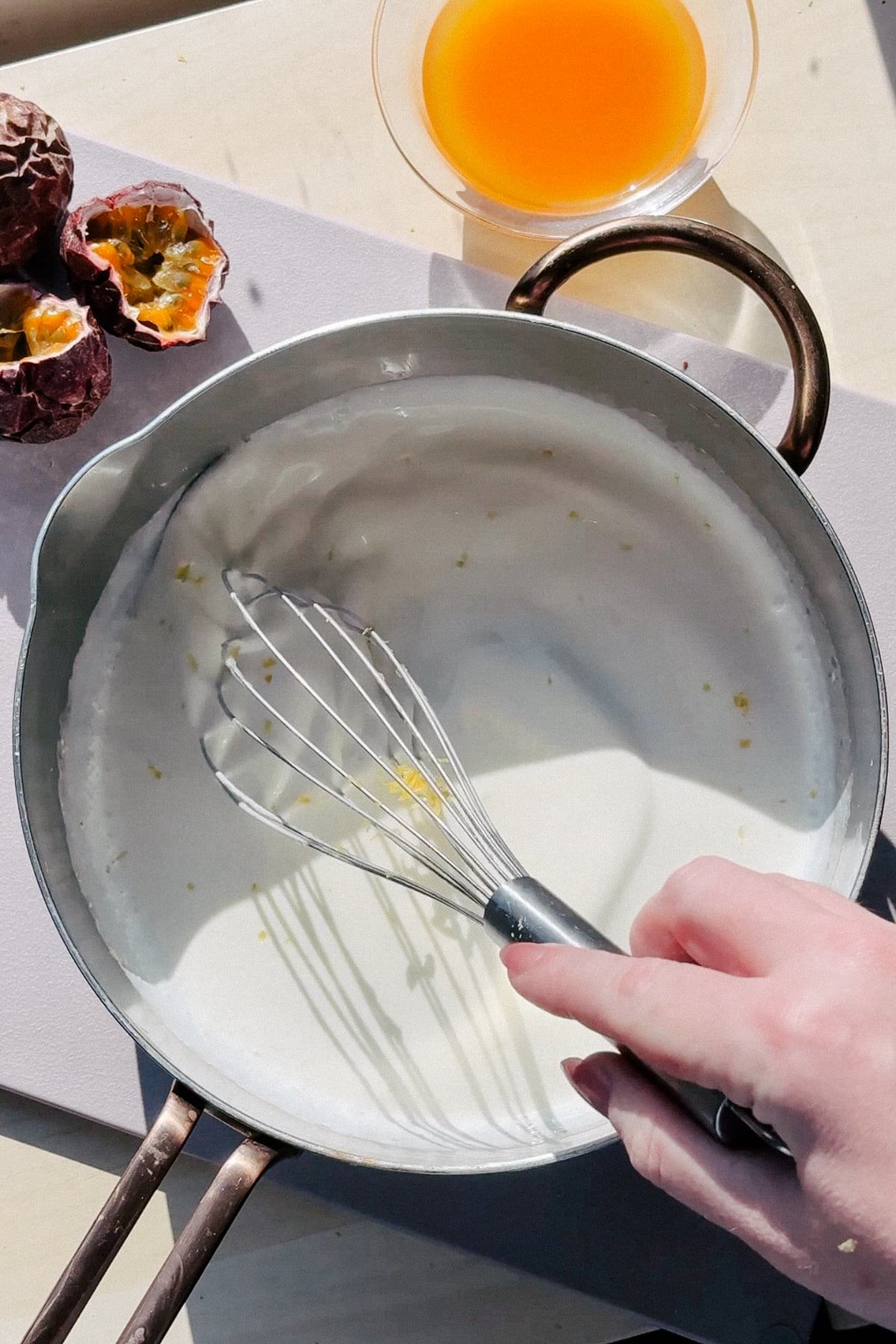 Whisking sugar and cream together with lemon zest. 