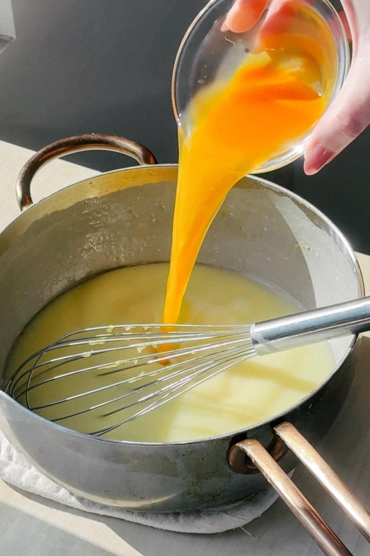 Pouring passion fruit puree into posset base. 