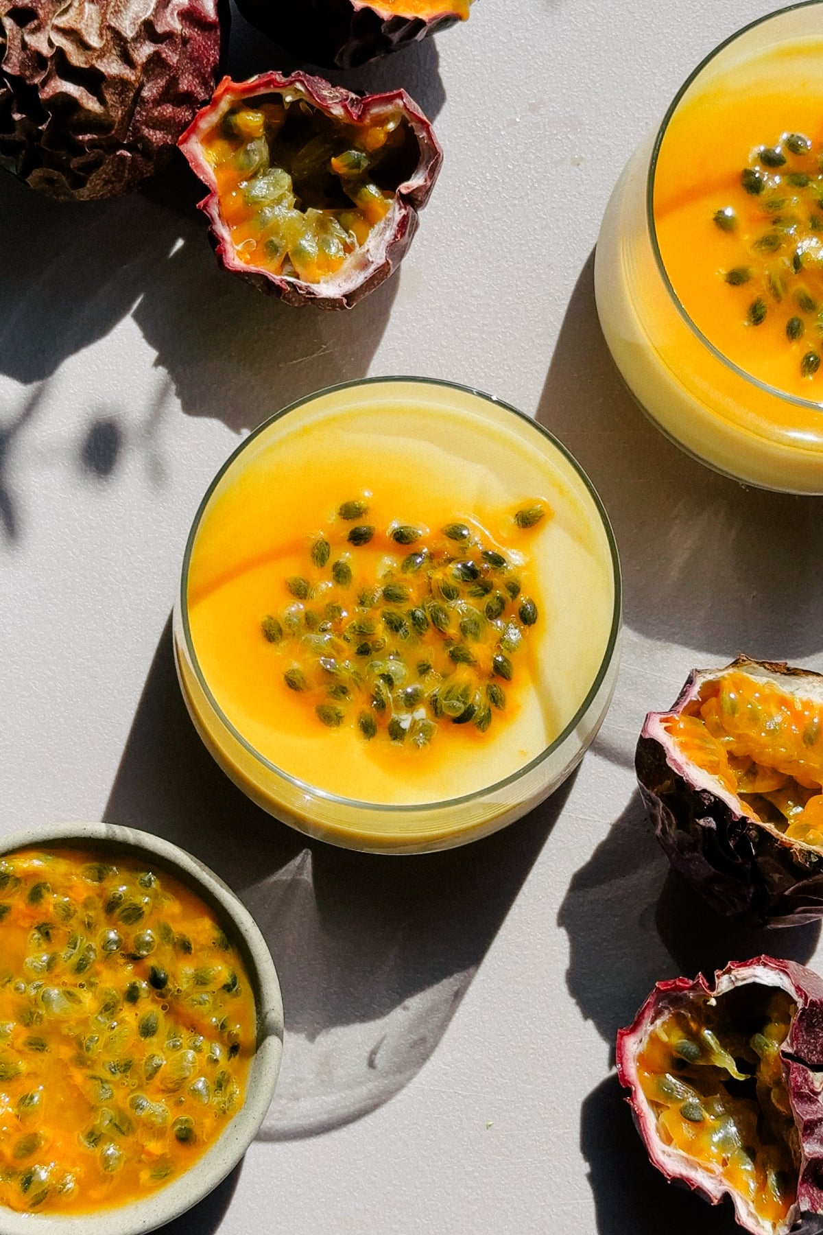 Passion Fruit Posset in small cups on a cutting board.