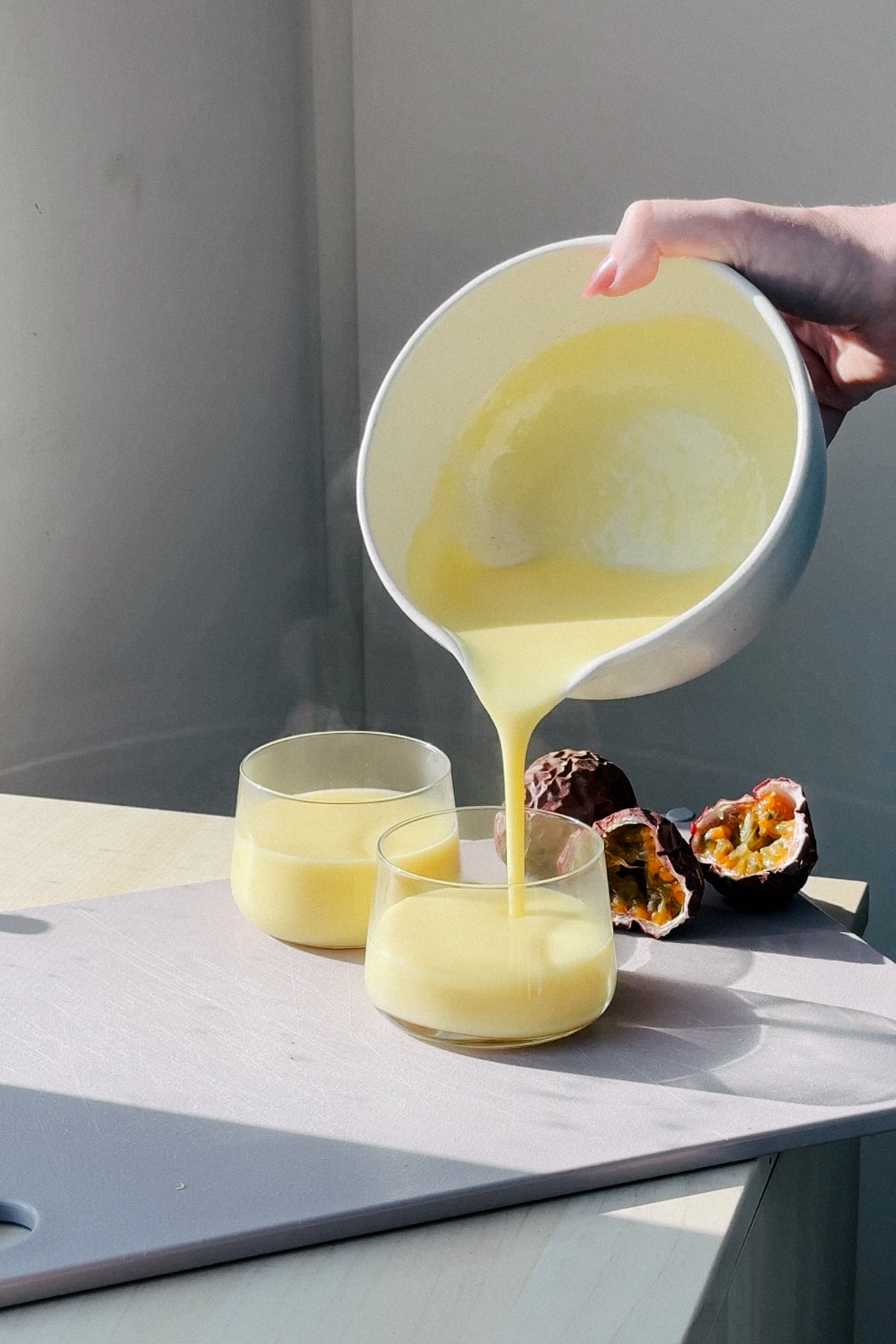 Pouring posset into two glasses prior to chilling. 