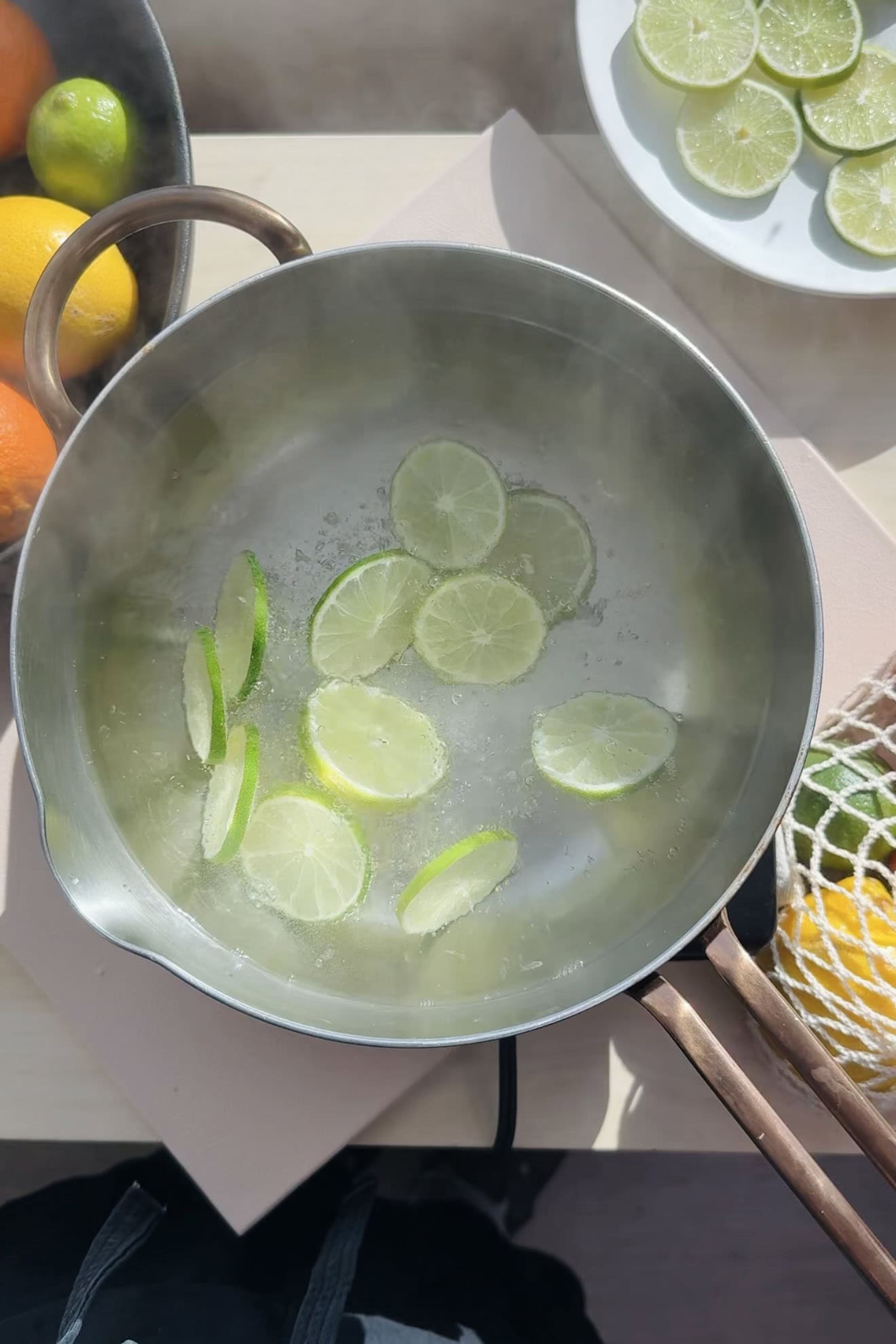 Blanching lime slices in a saucepan with water.