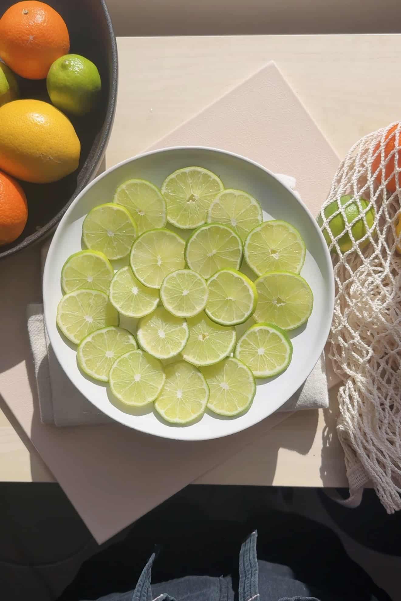 Plate of limes on the counter.
