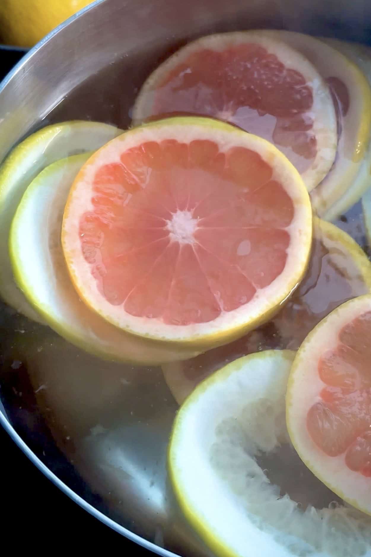 Blanching grapefruit slices in water before an ice bath.