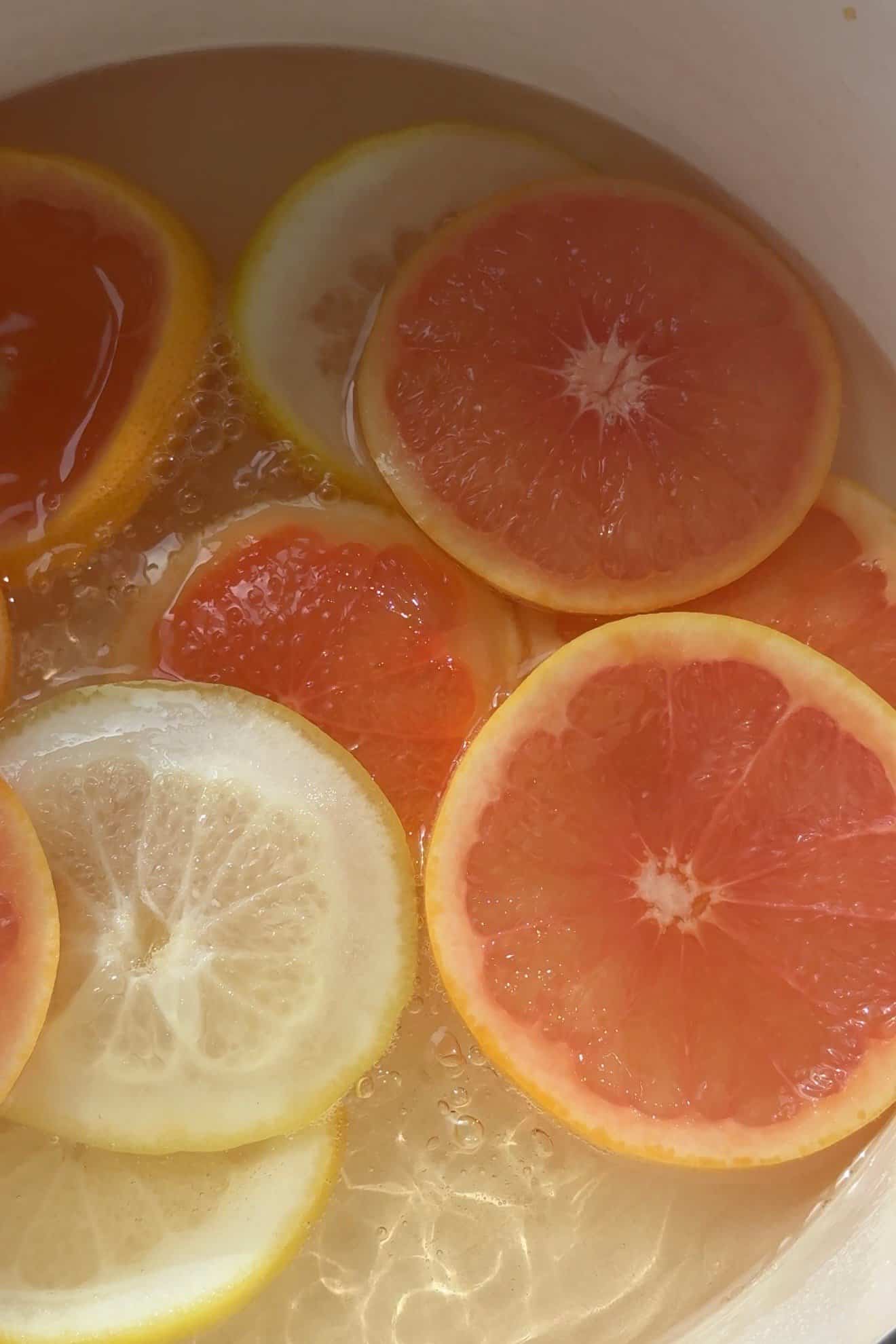 Grapefruit slices simmering in syrup. 