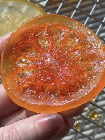 Candied grapefruit next to a cooling rack.