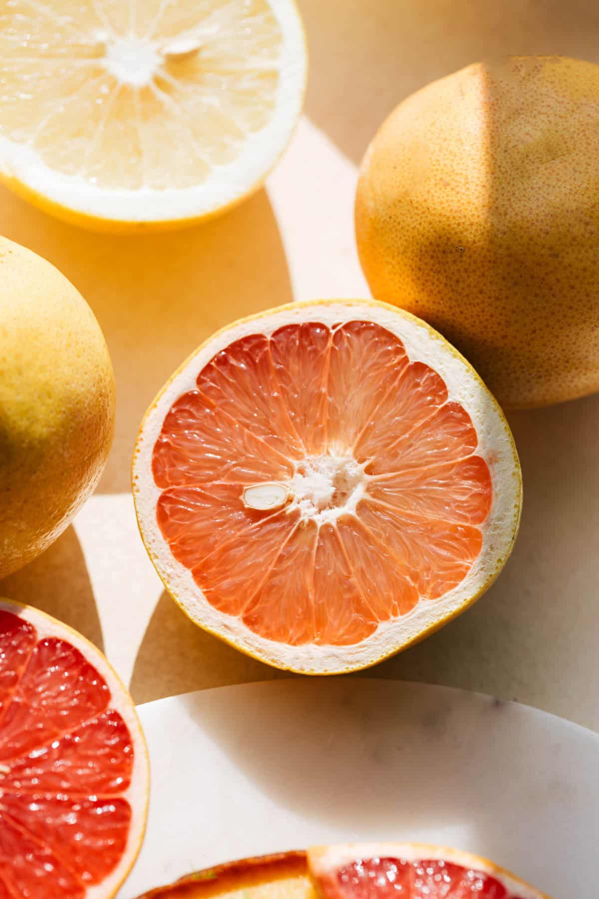 Cut grapefruit on a cutting board.