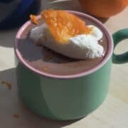 French hot chocolate with softly whipped cream and a candied orange.