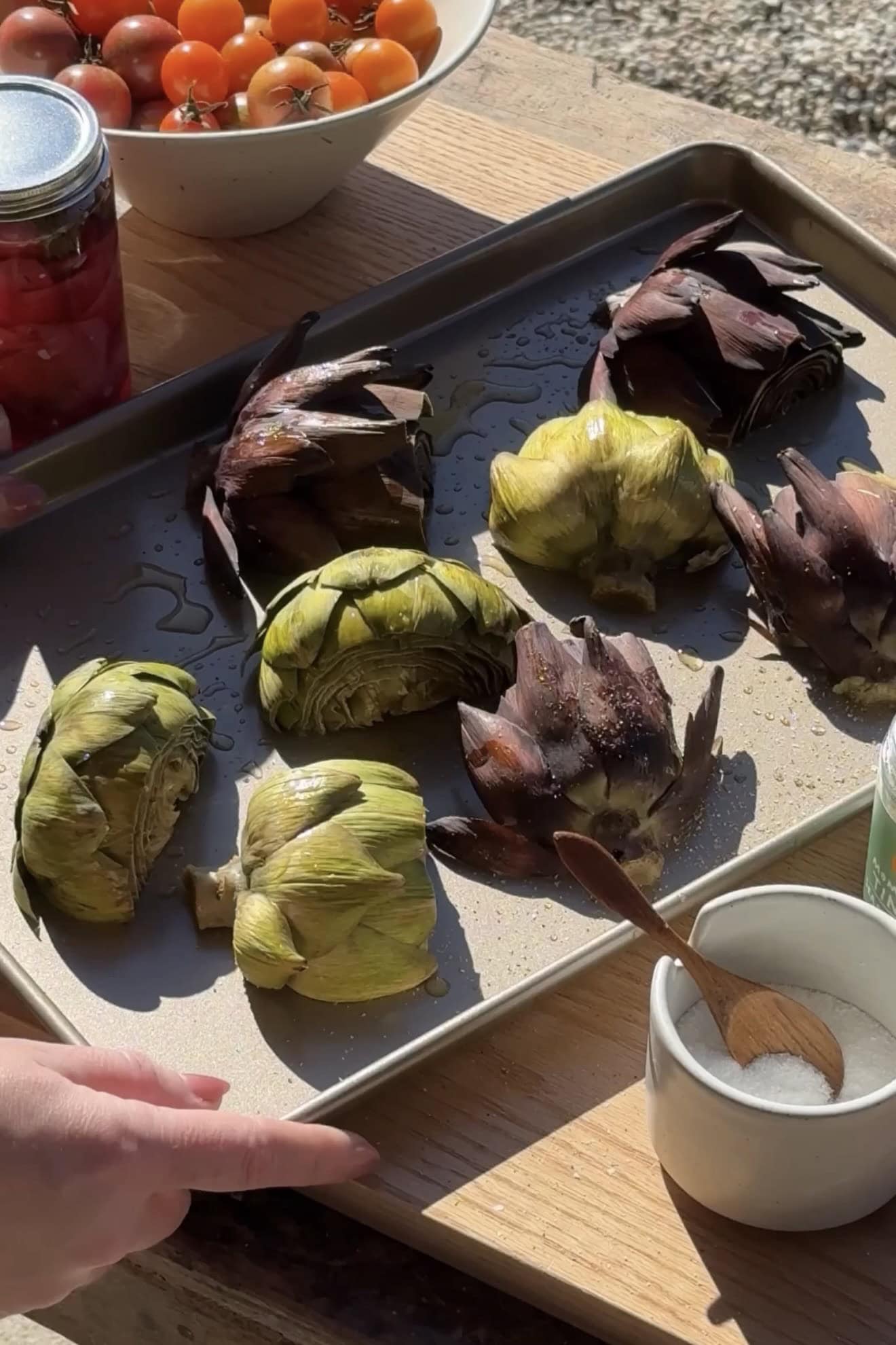Adding artichokes to baking sheet.