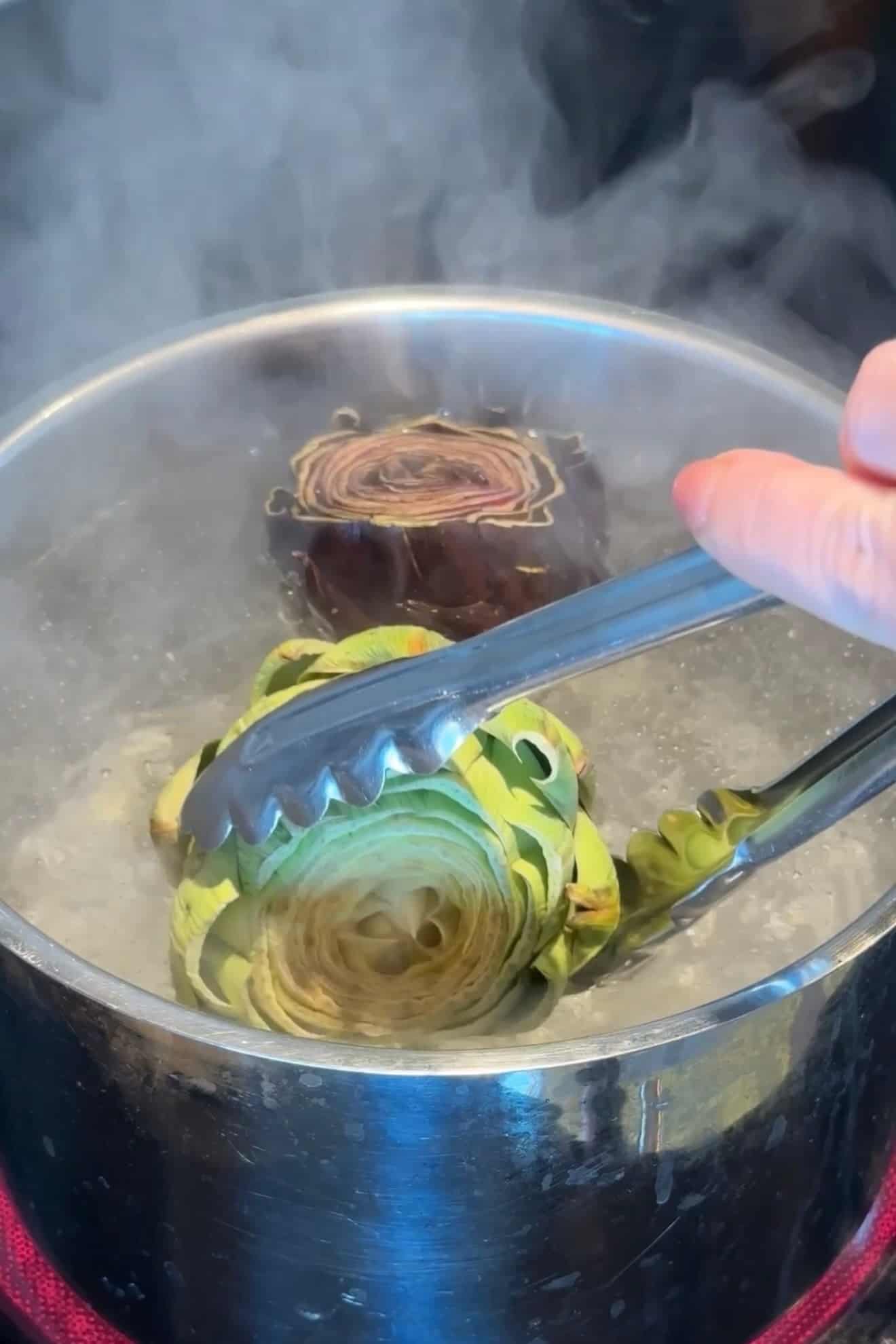 Boiling artichokes in a saucepan.
