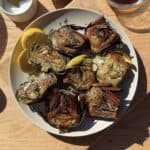 Roasted crispy artichokes on a serving platter.