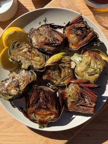 Roasted crispy artichokes on a serving platter.