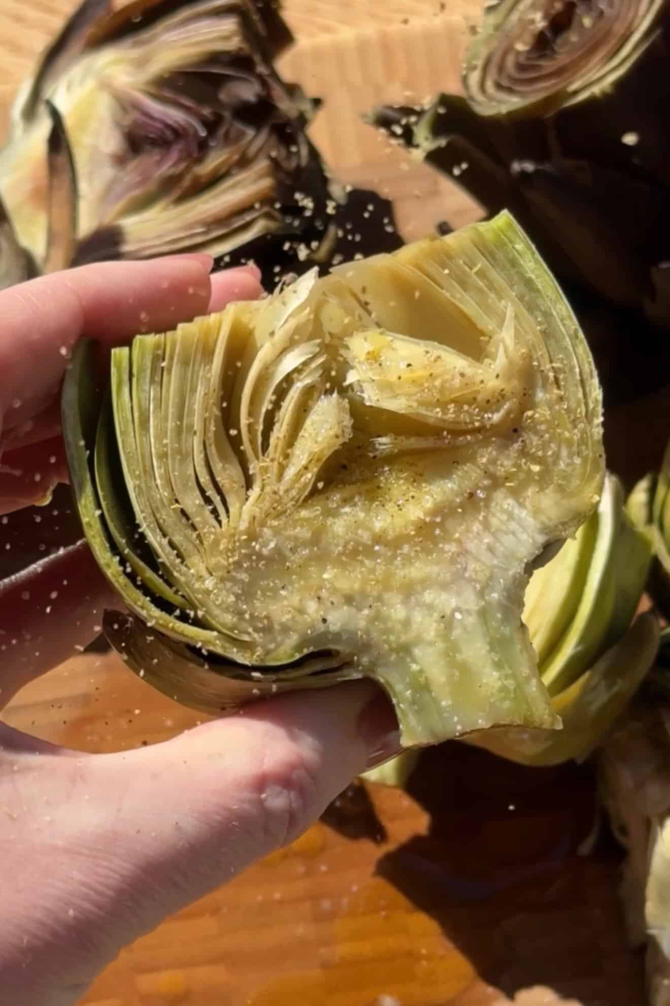 Adding seasonging to artichokes.