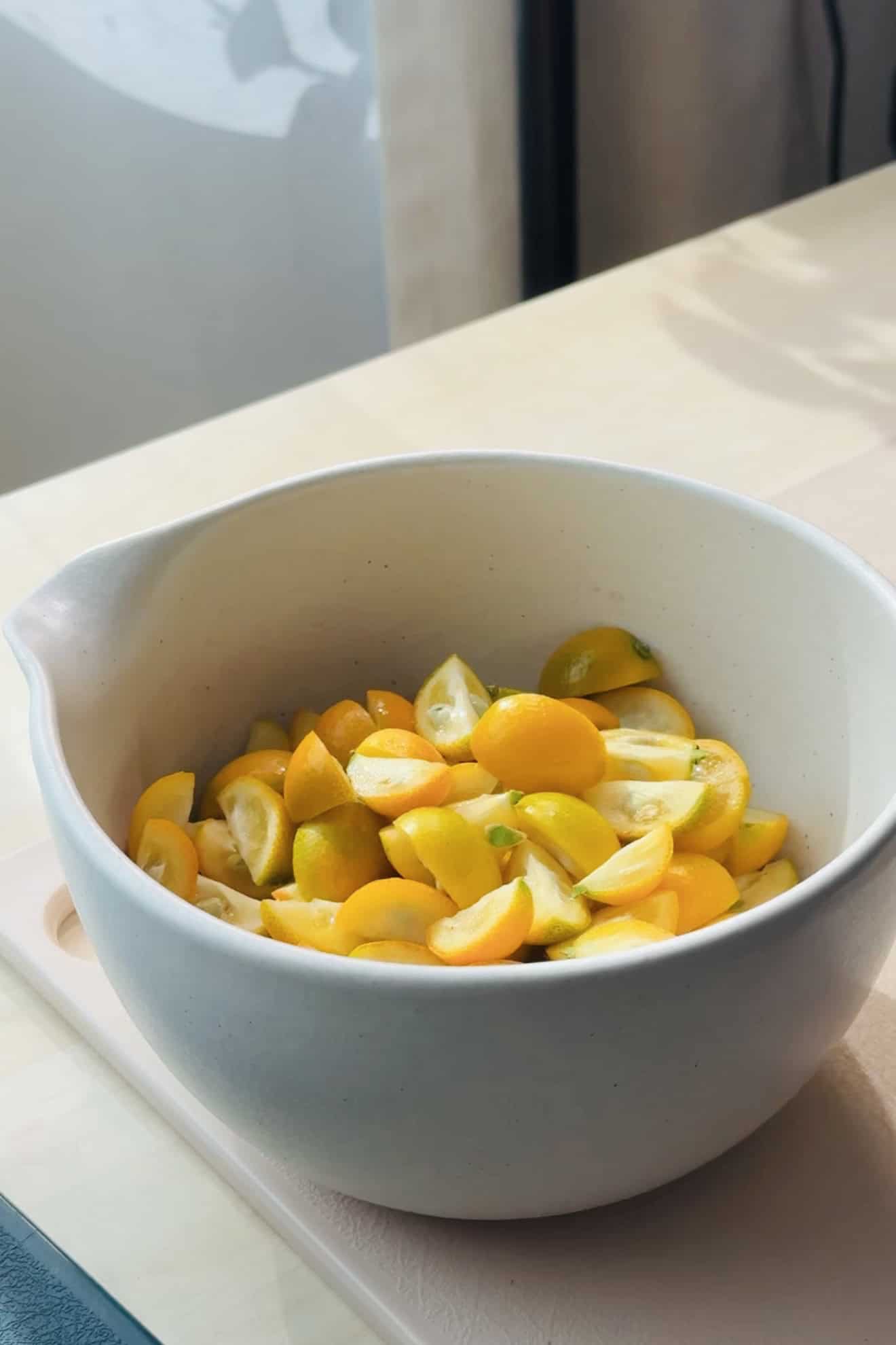 Bowl of kumquats that are sliced and fresh. 