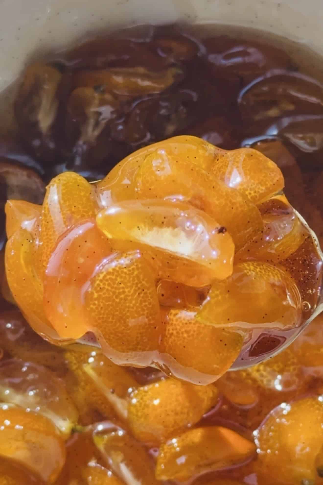 Spoonful of candied kumquats in a spoon.